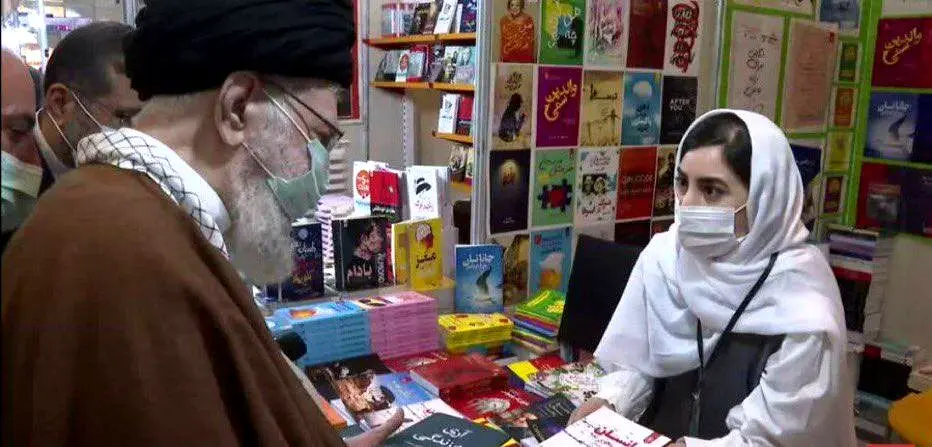 معرفی کتاب به رهبر انقلاب توسط دختری جوان  با پیراهن و شلوار  | تصویر